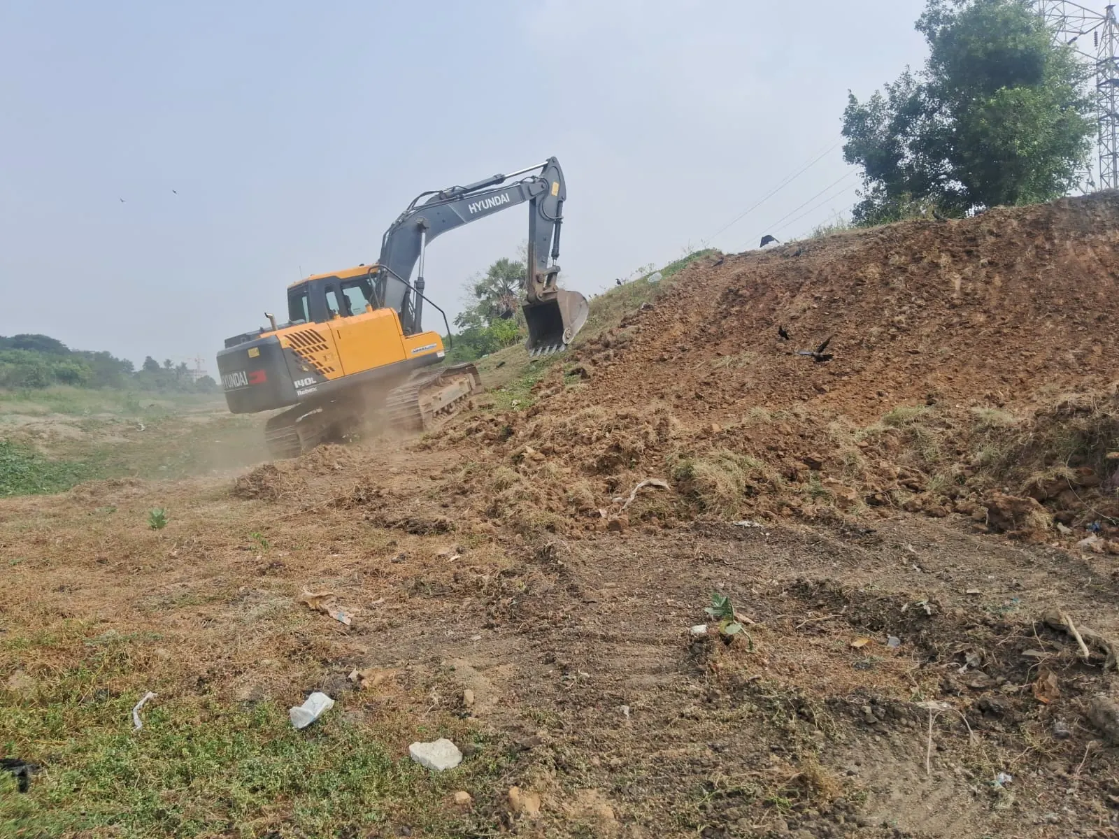 An excavator reshaping the bank of Puduthangal Lake, 13 October 2026
